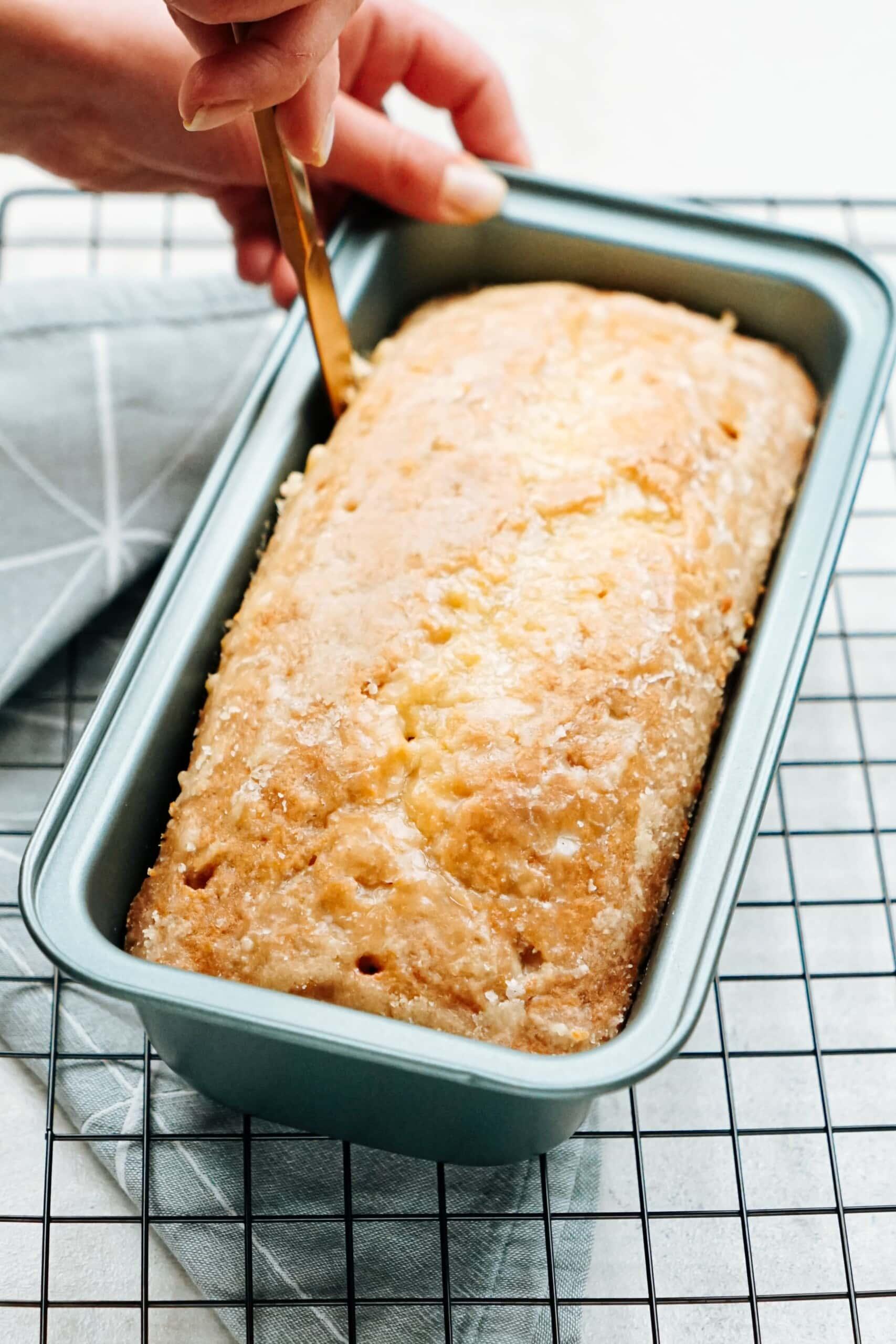 running a knife around the edges of the bread to loosen