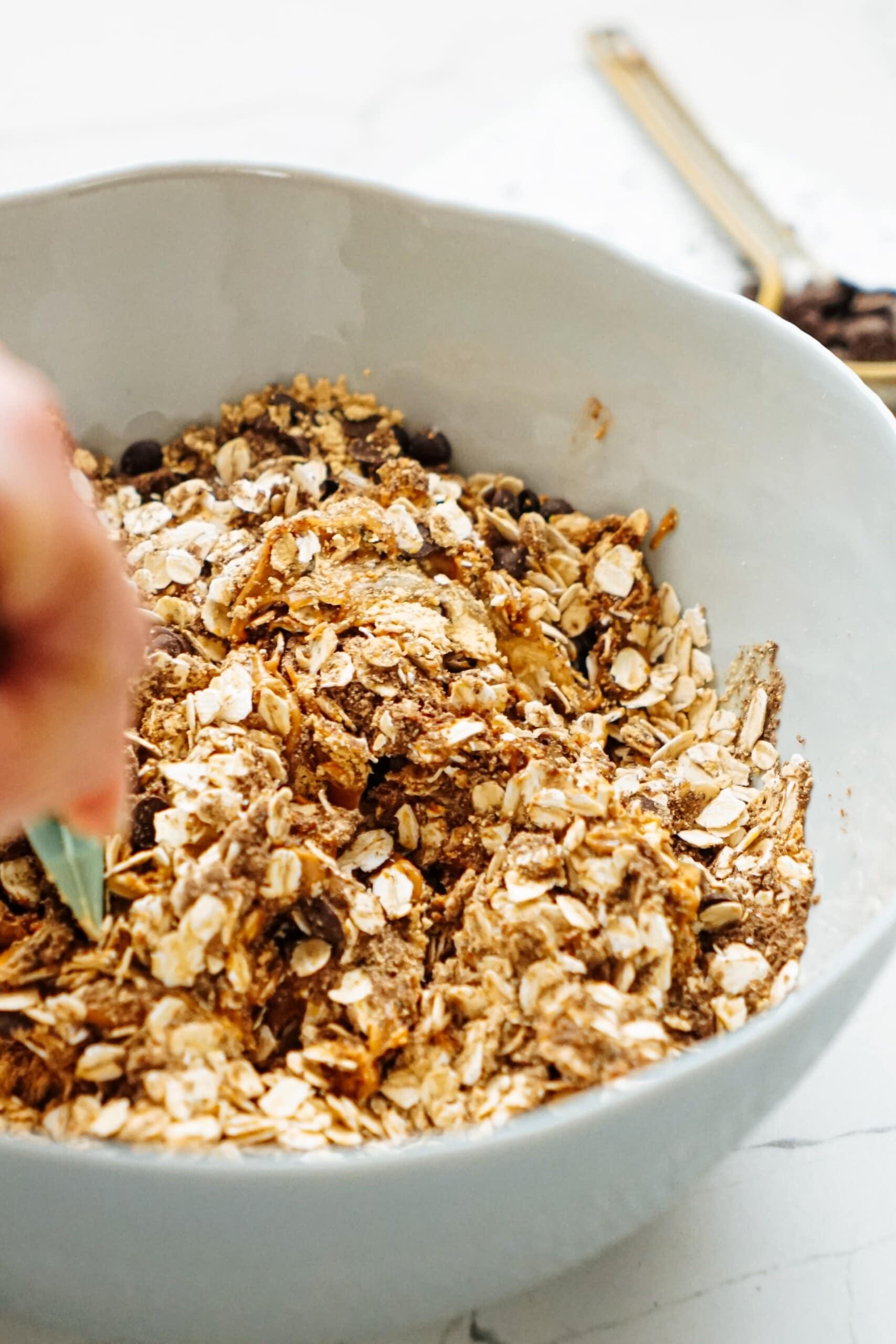 womans hand using a rubber spatula to combine ingredients