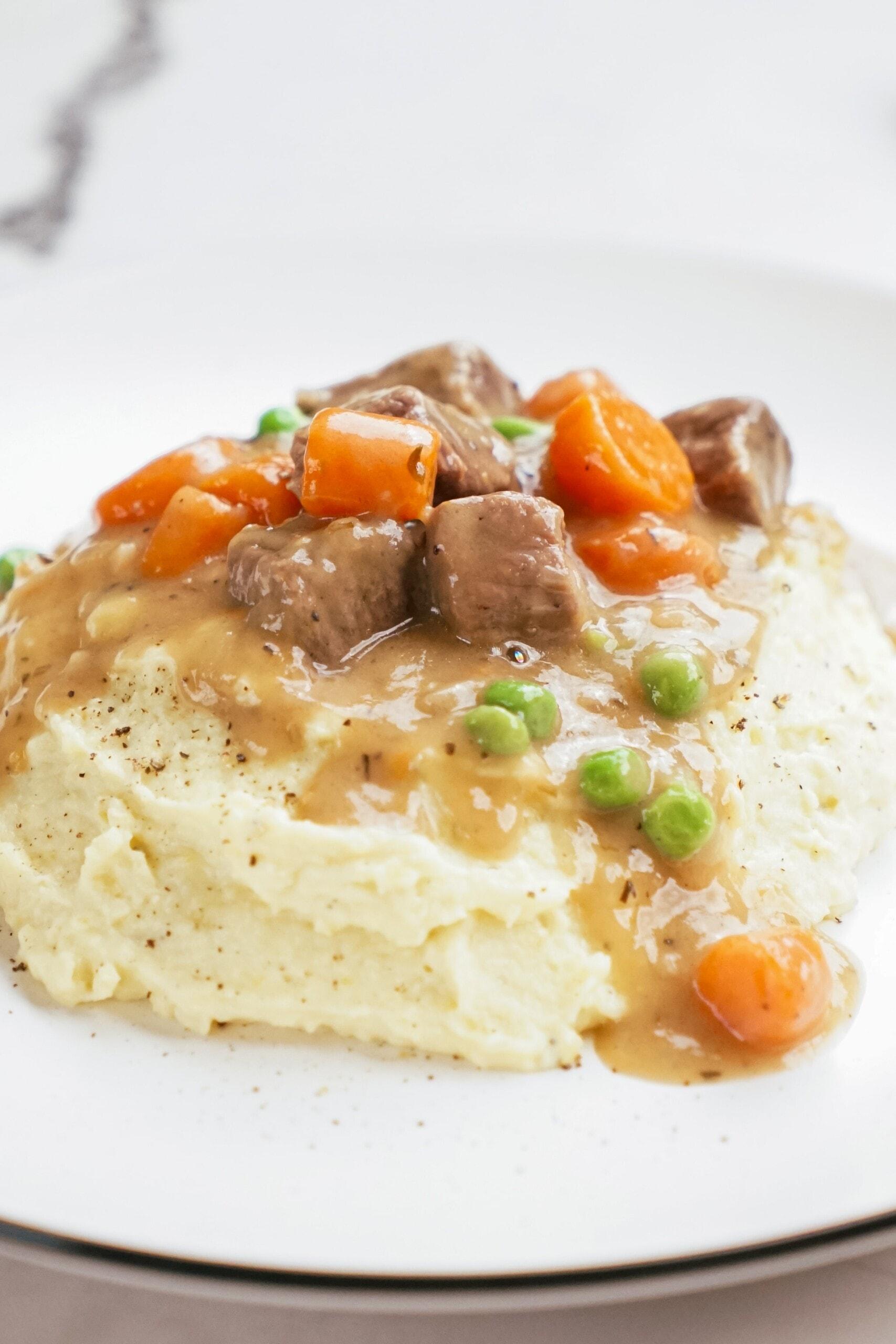 irish beef stew with mashed potatoes on plate