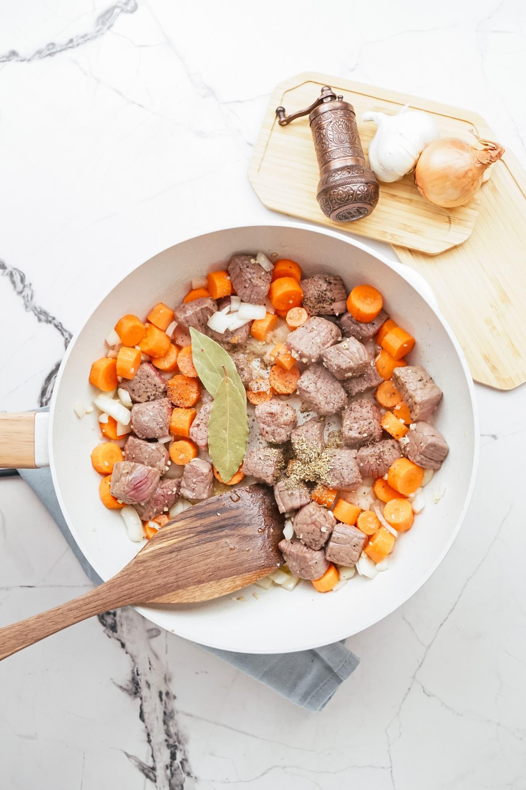 beef stew ingredients cooking in pan