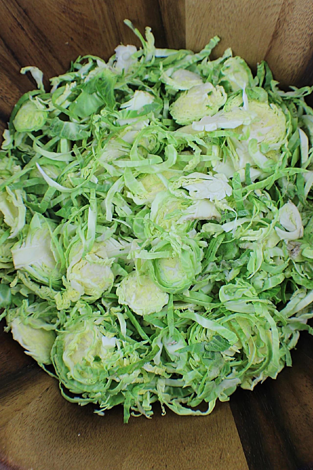 shaved Brussels Sprouts in wooden salad bowl