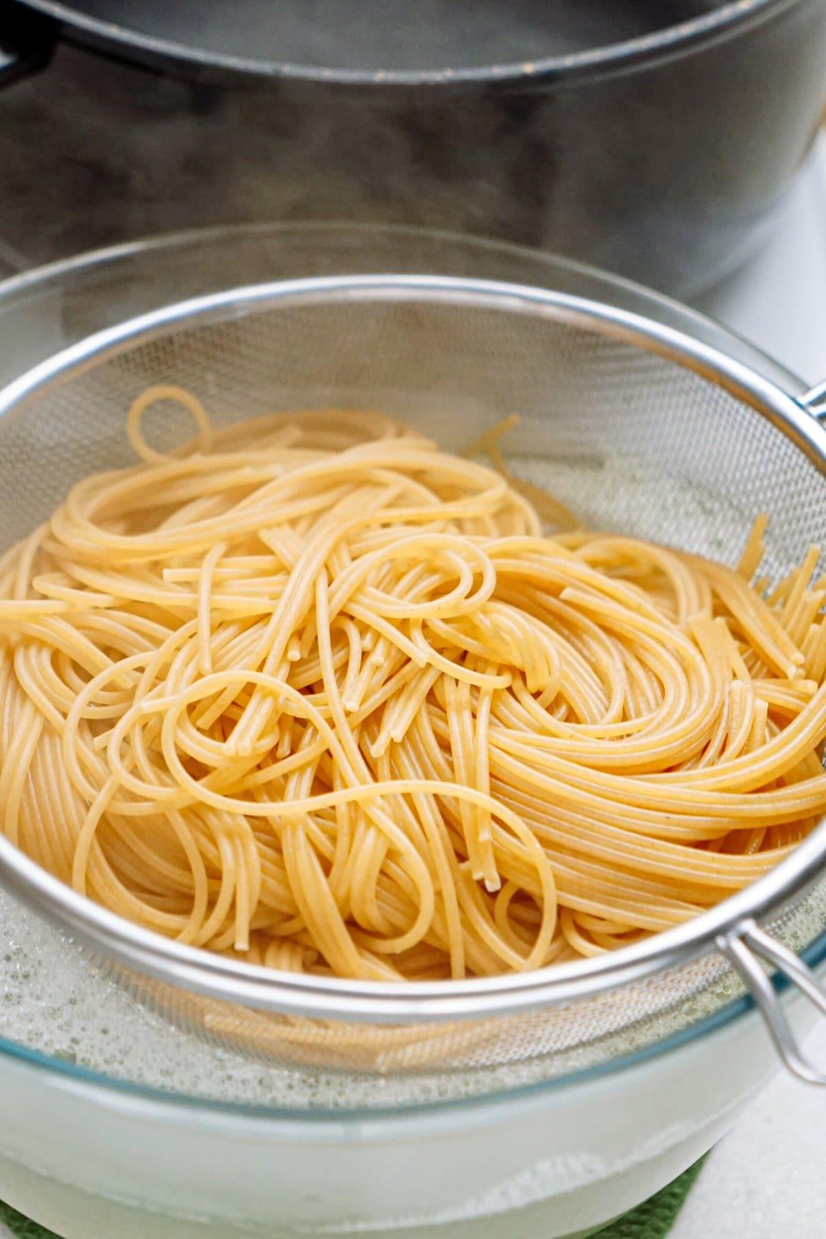 cooked spaghetti noodles in a strainer