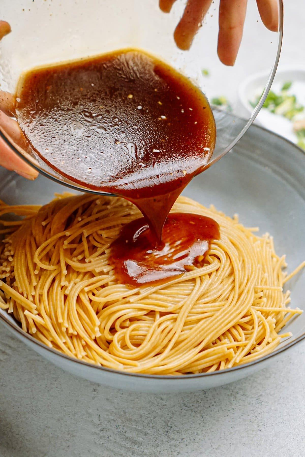 sesame dressing poured over cooked noodles