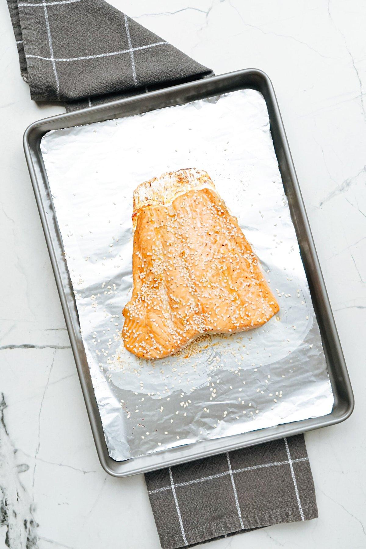 Salmon fillet on a baking sheet, ready to be cooked.