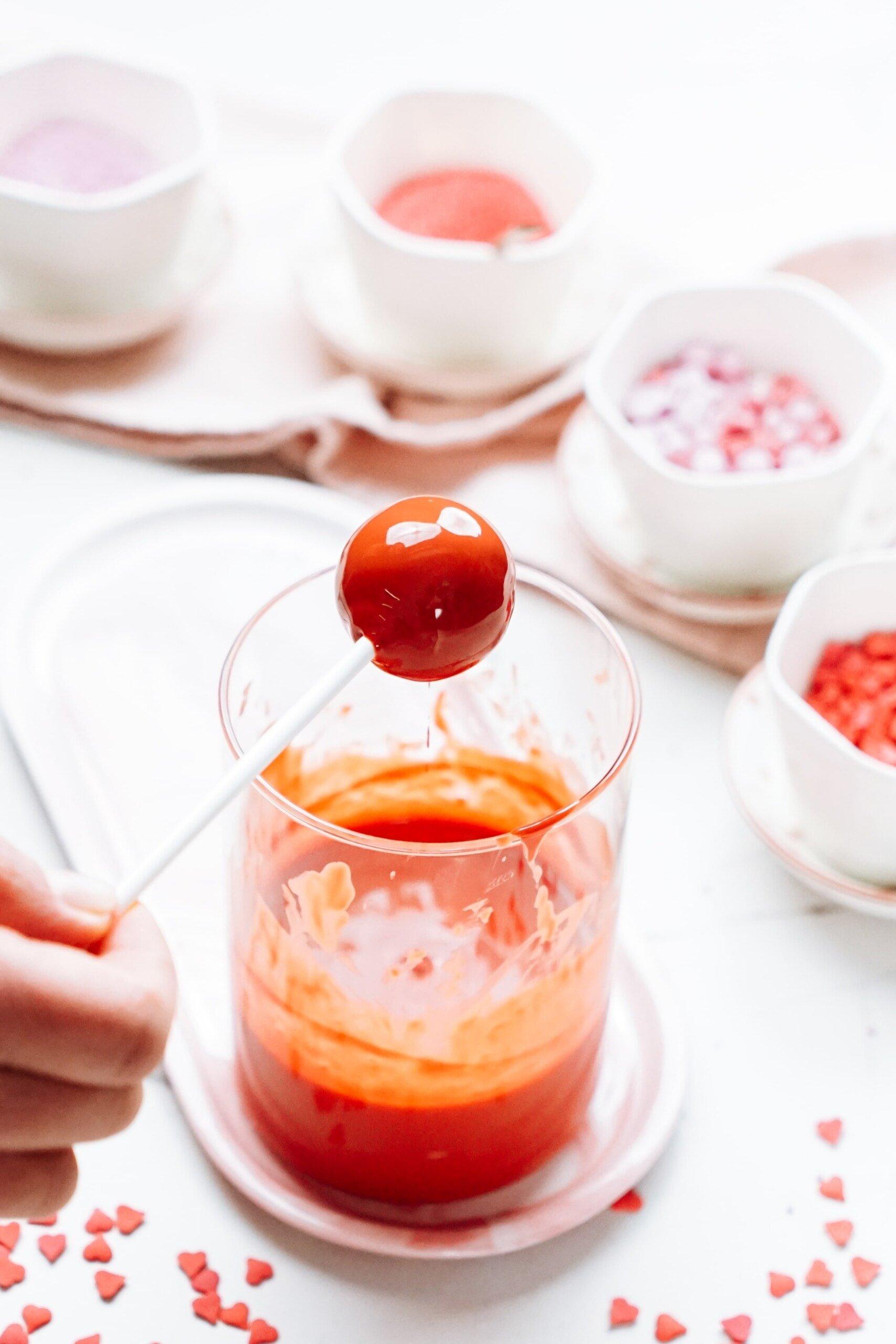 letting excess chocolate drip off the cake ball 