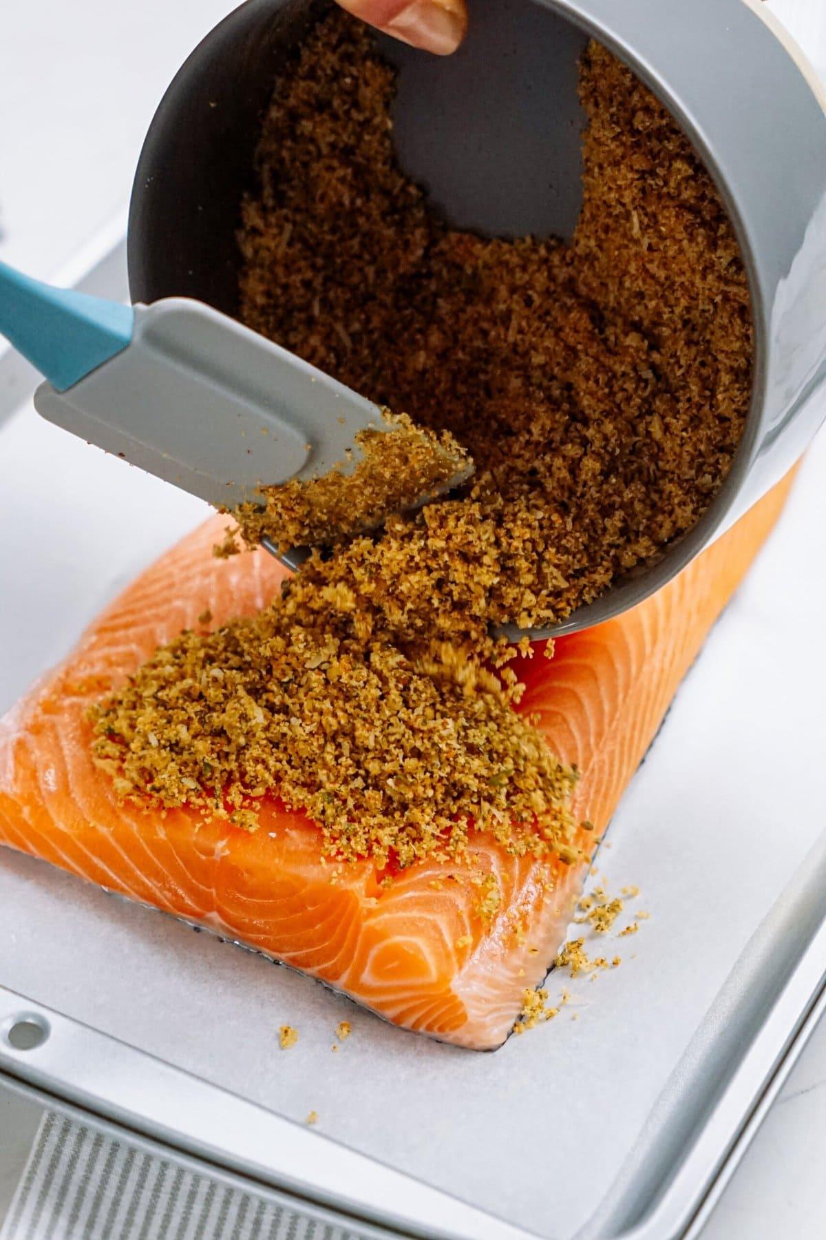 adding bread crumb mixture onto of salmon fillet