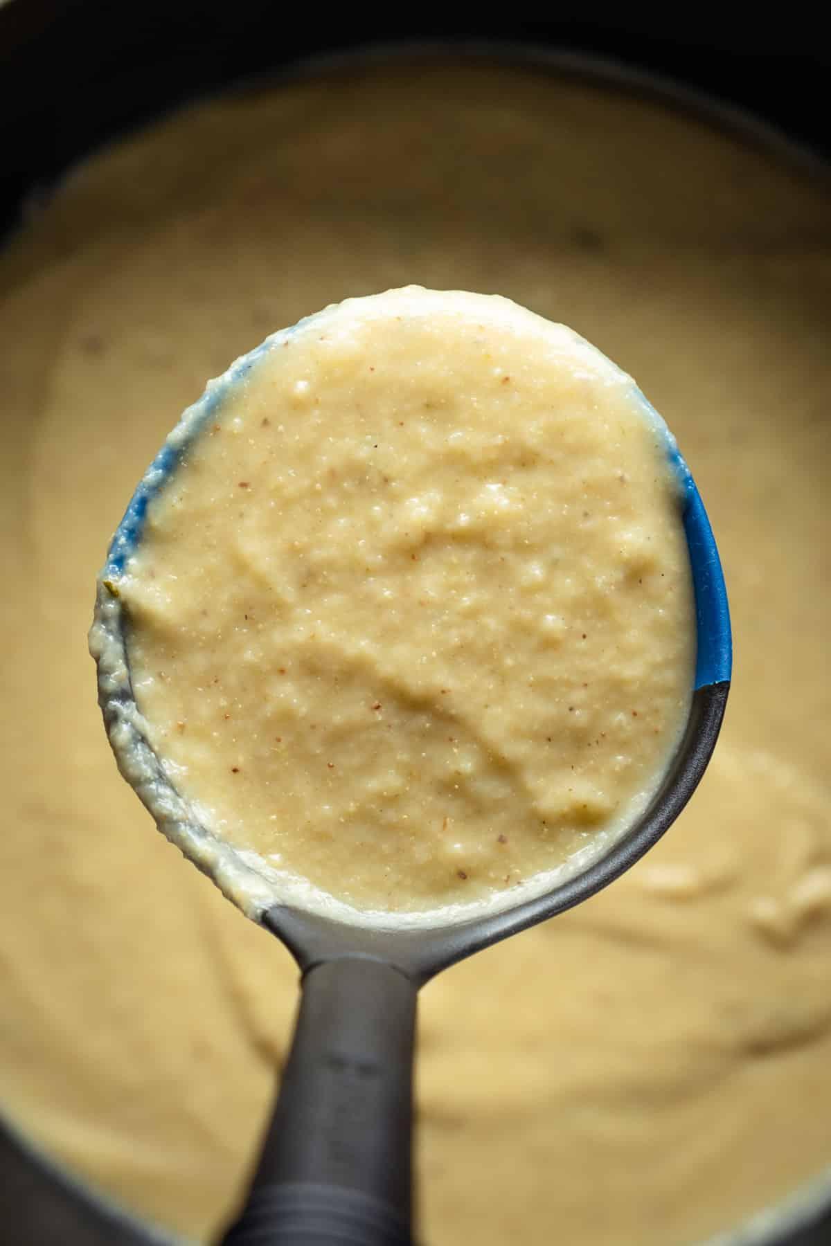 A soup ladle with Vegan Roasted Cauliflower Soup