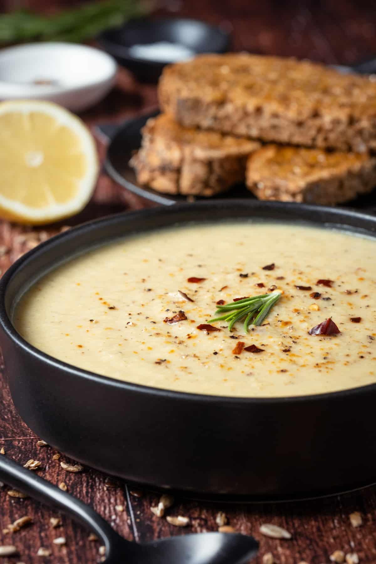 Vegan Roasted Cauliflower Soup served with a sprinkle of black pepper, fresh rosemary and red pepper flakes