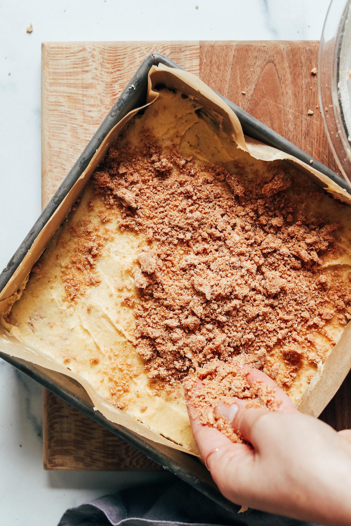 Sprinkling a crumble topping over the coffee cake batter