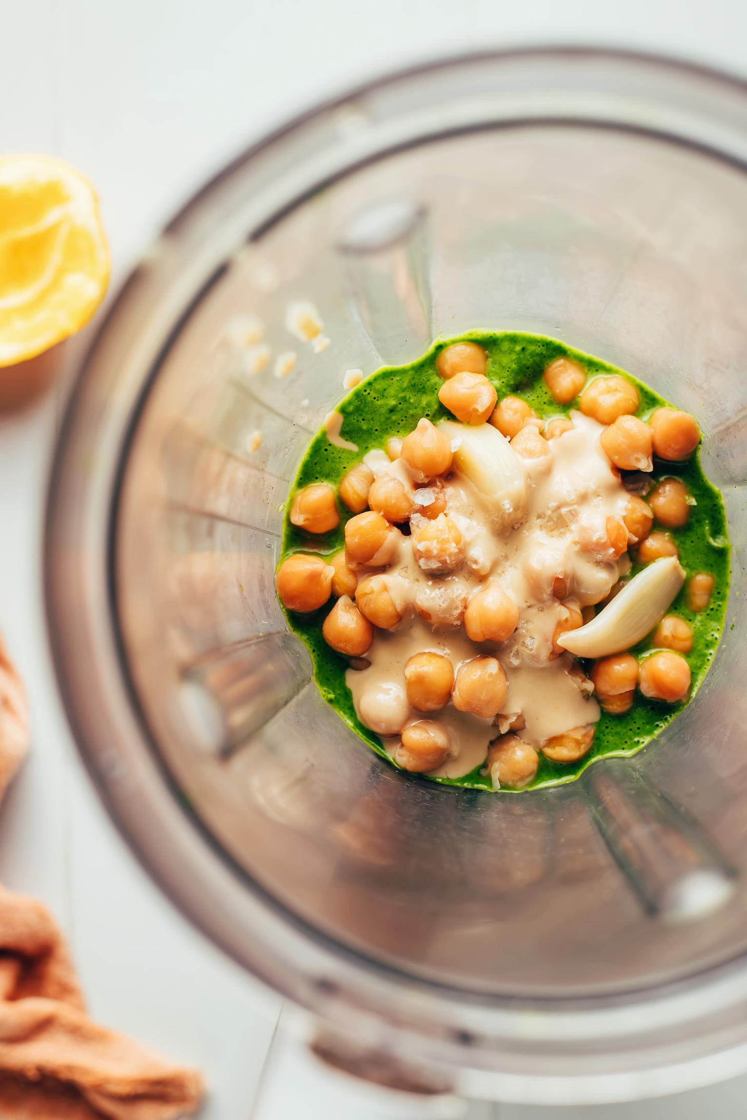 Garlic cloves, salt, and chickpeas over an herby green sauce