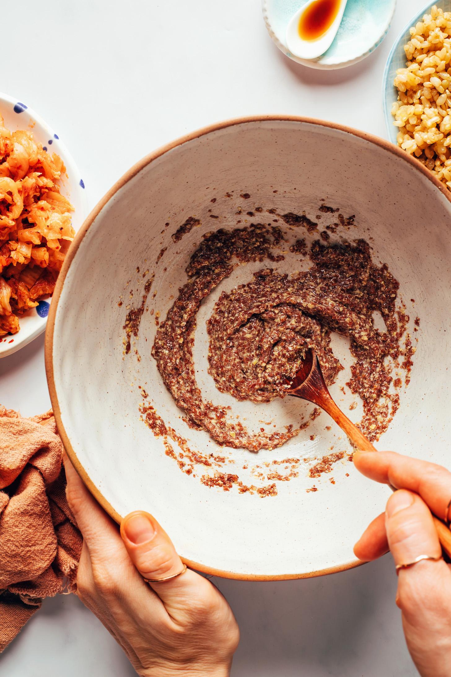 Stirring flaxseed meal and water in a bowl to make a flax egg