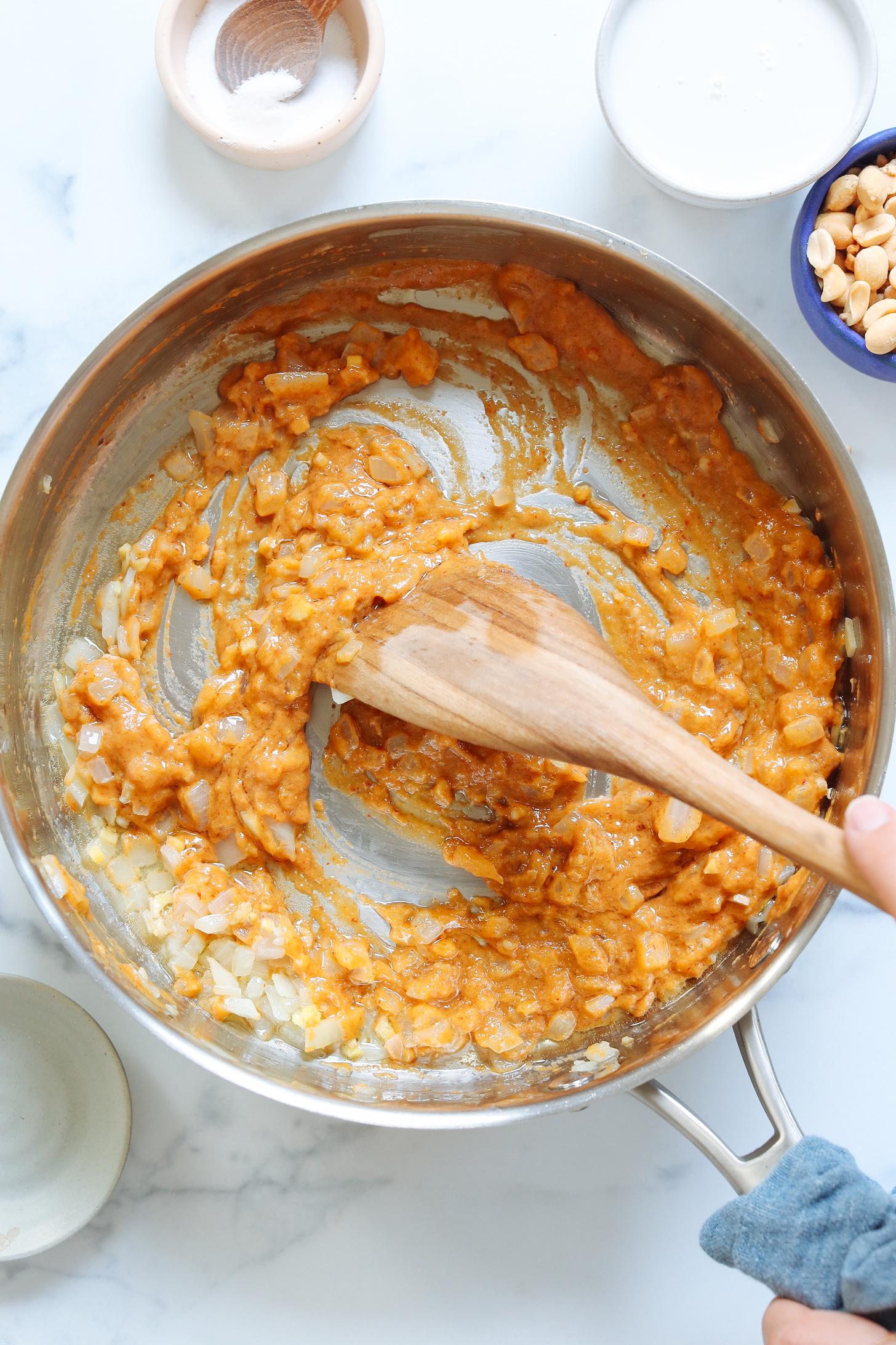 Sautéing onion, garlic, ginger, and curry paste in a rimmed skillet