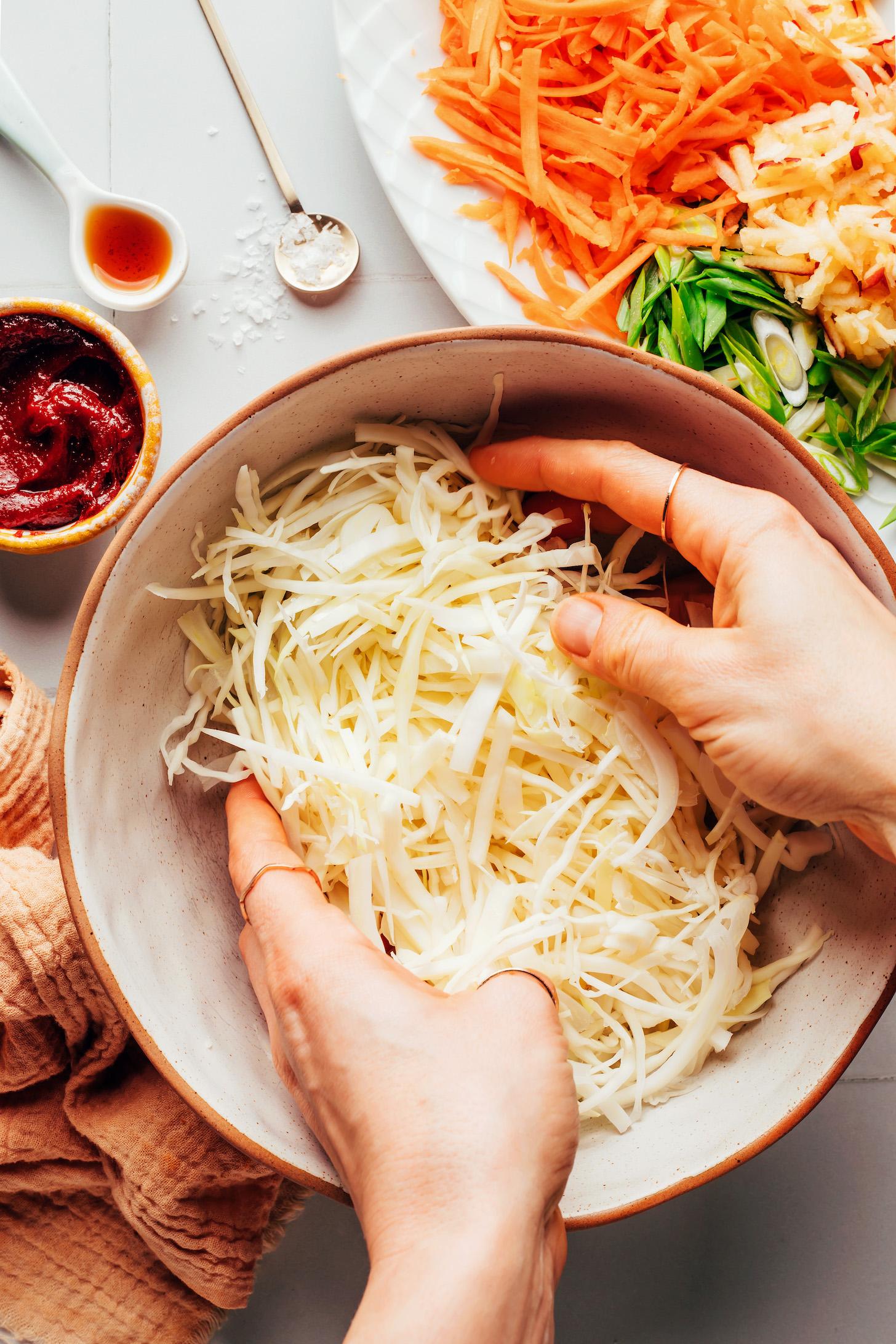 Massaging green cabbage in a bowl