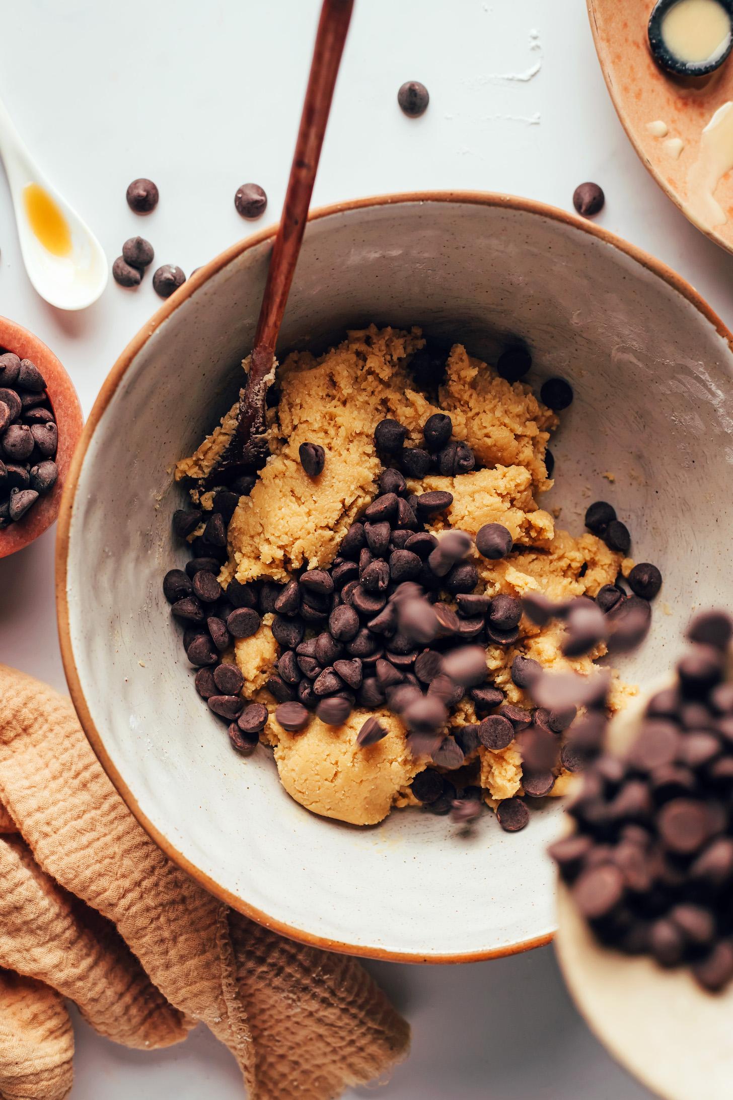 Pouring chocolate chips into cookie dough