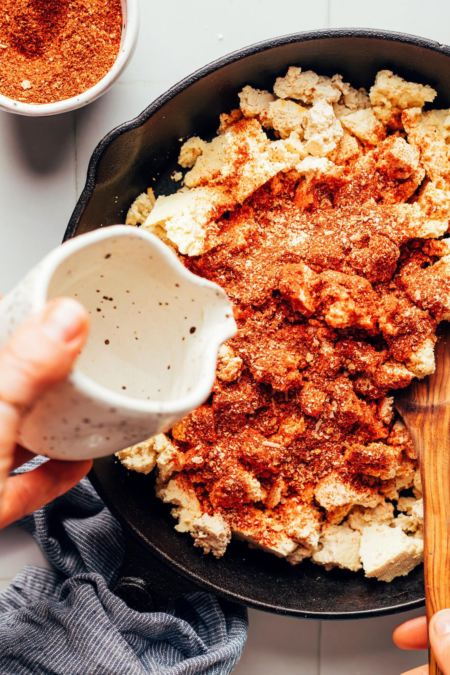 Pouring water over crumbled tofu and taco seasoning