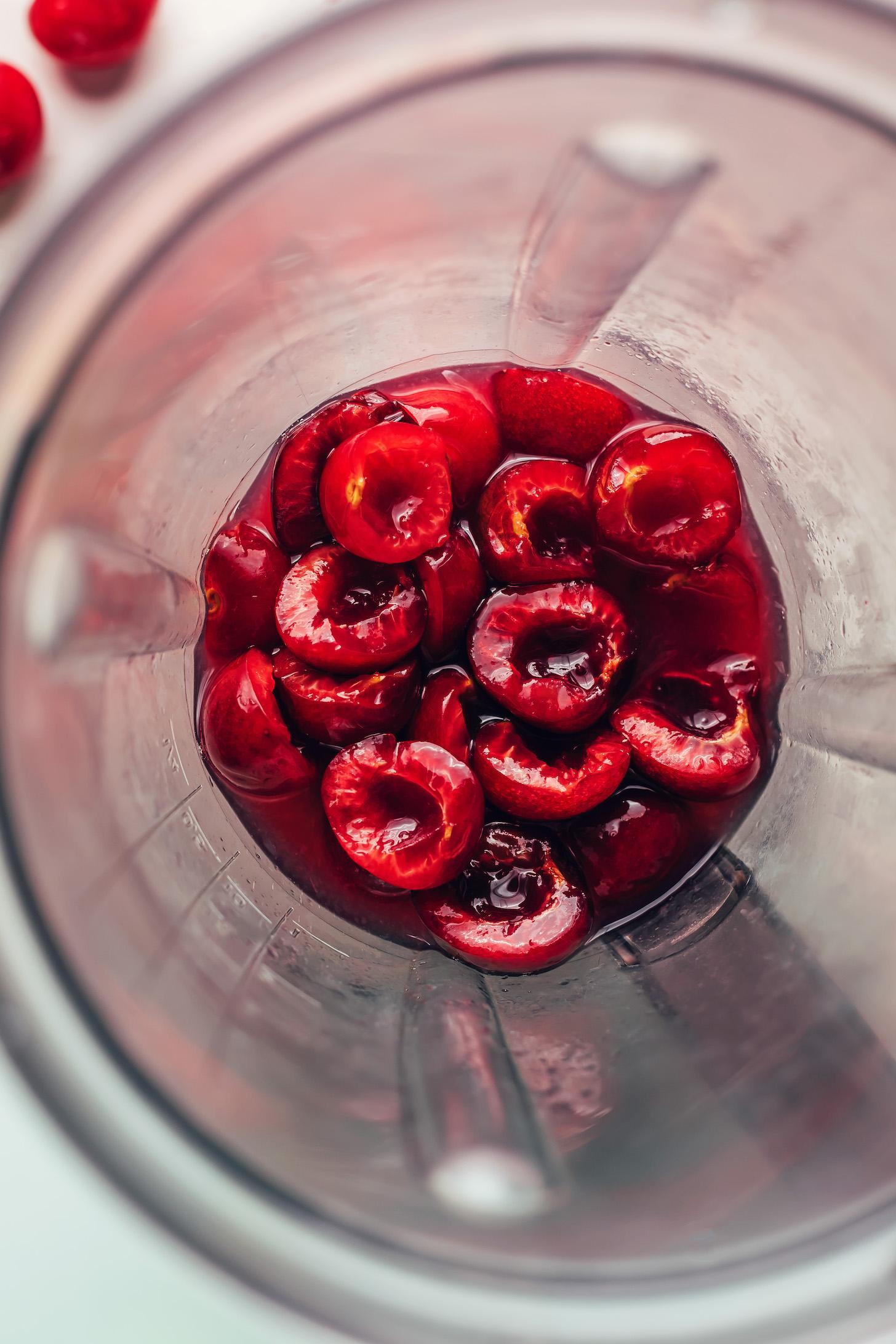 Blender with pitted cherries, lime juice, and maple syrup