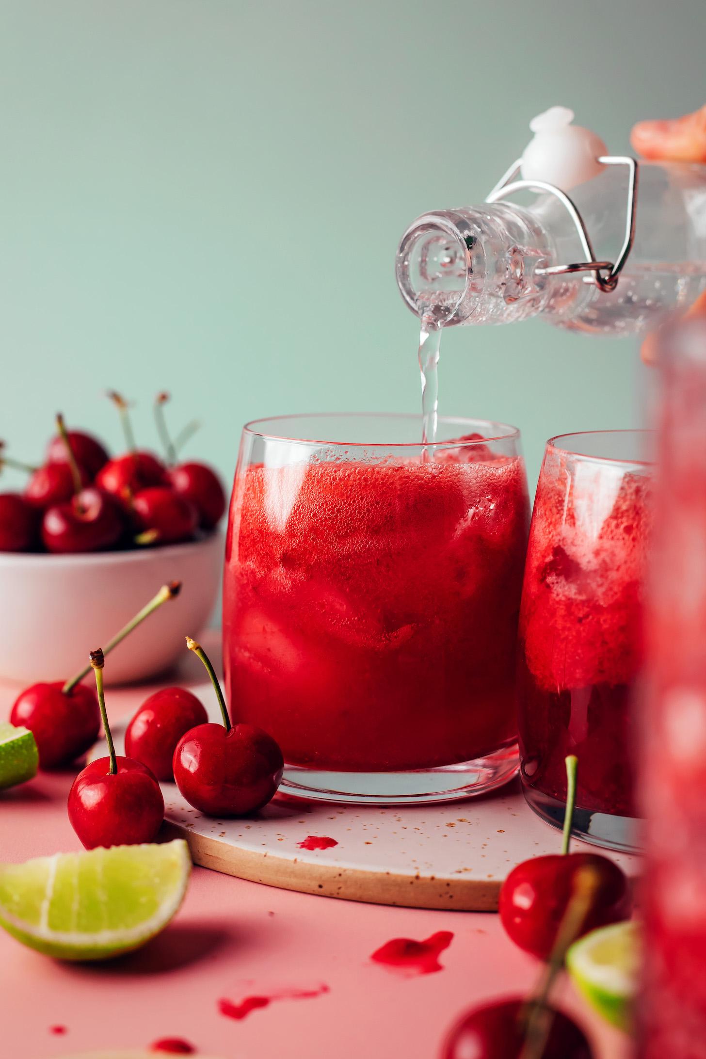 Pouring sparkling water into a glass to make sparkling cherry limeade