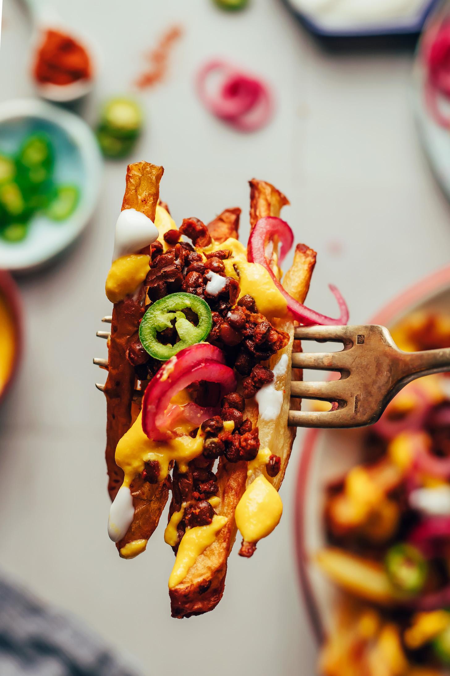 Vegan chili cheese fries speared onto a fork