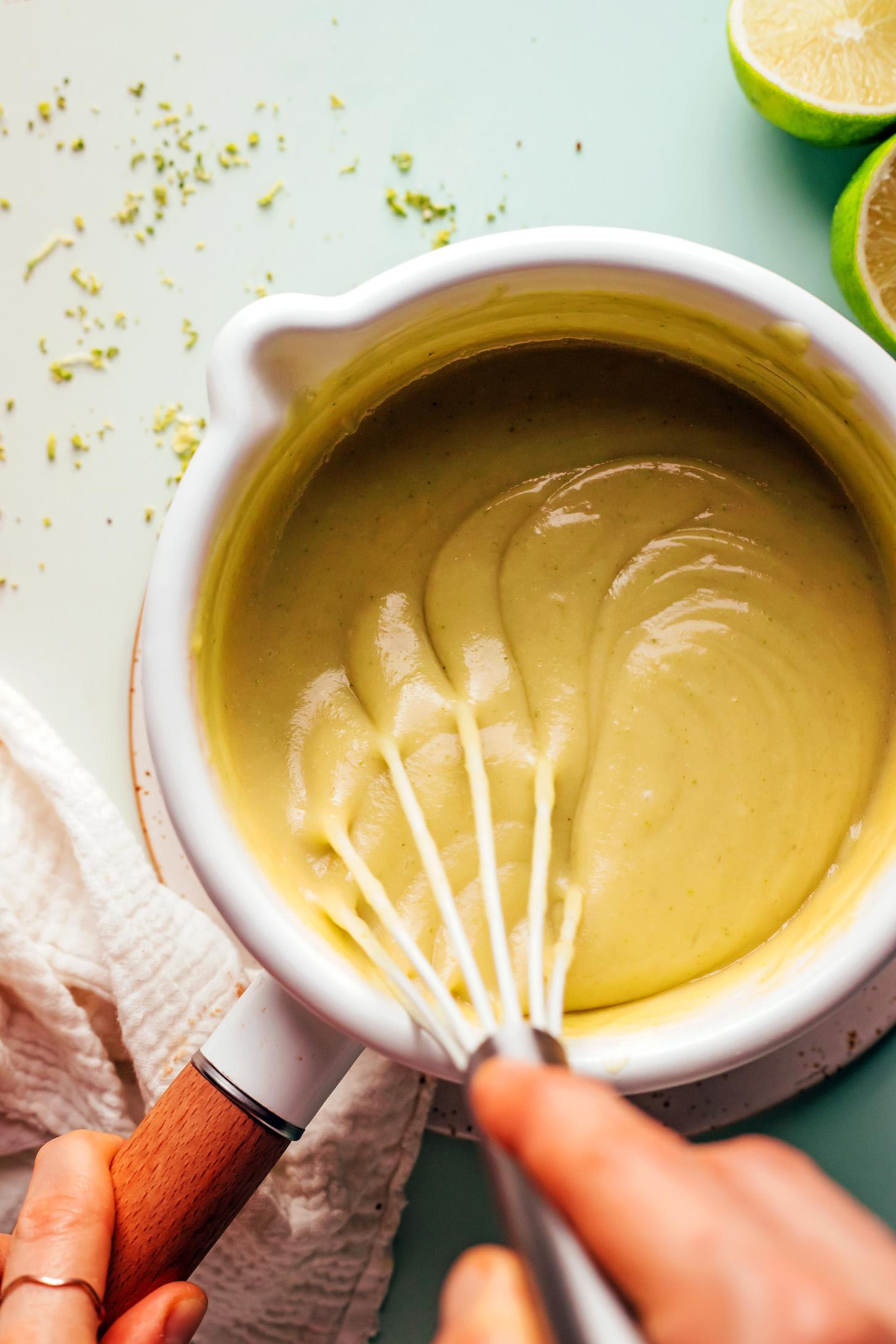 Whisking a vegan lime curd in a saucepan