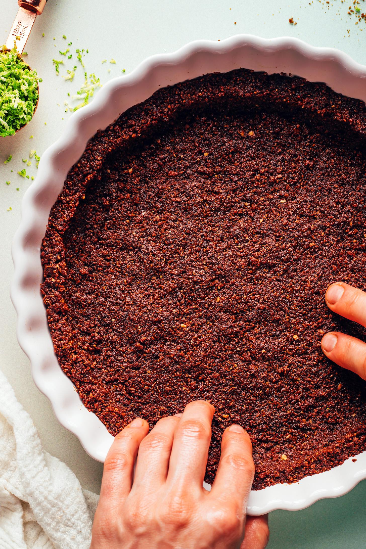 Pressing a gluten-free graham cracker crust into a pie pan