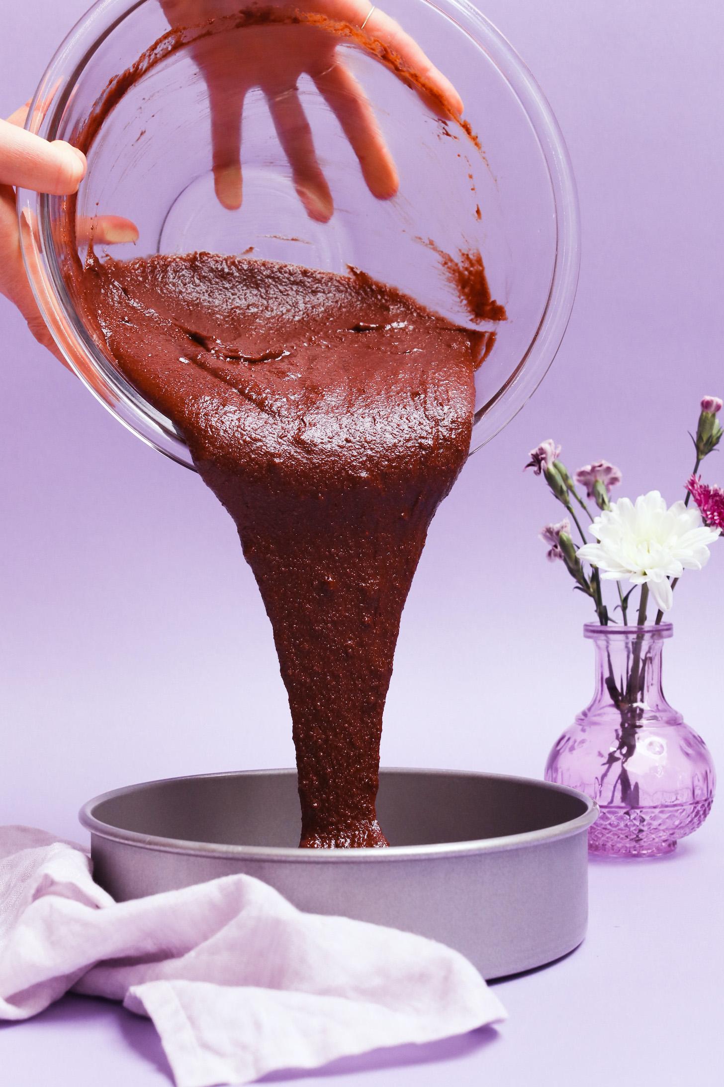 Pouring batter from a mixing bowl into a cake pan