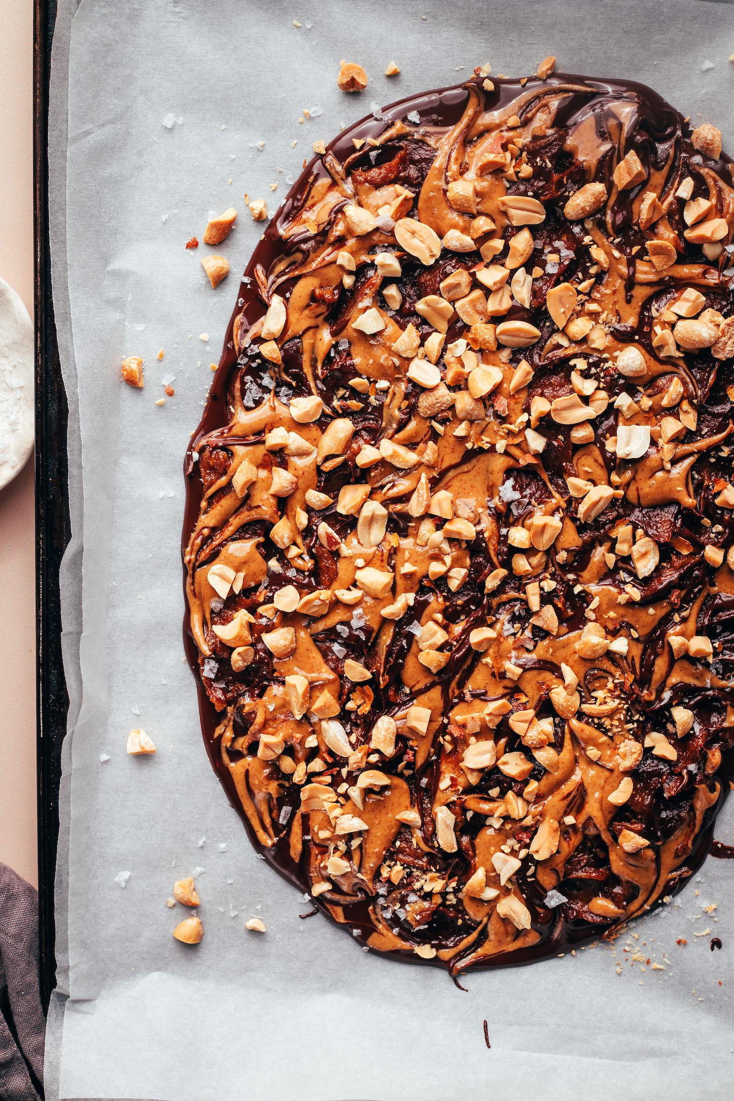 Snickers chocolate bark on a baking sheet before freezing