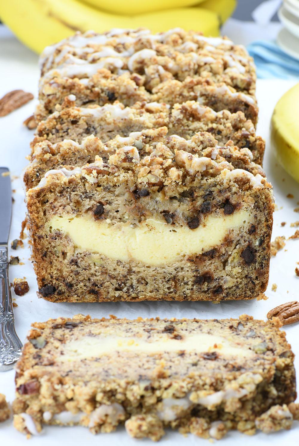 Couple of slices of Cream Cheese Banana Bread with banana and pecan decoration.