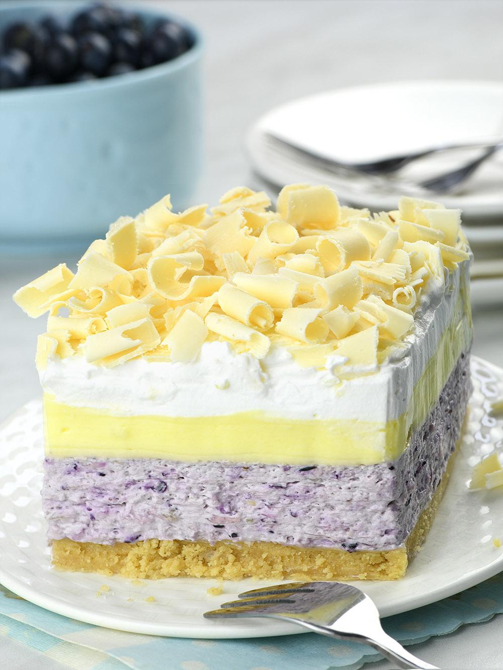 Piece of No Bake Lemon Blueberry Dessert with tree dessert layers.