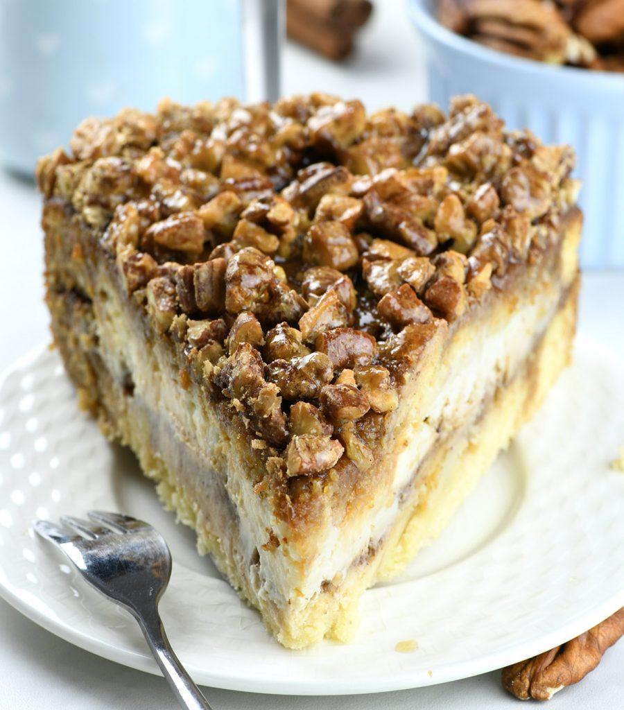 Pecan Pie Cheesecake Coffee Cake on a white plate .