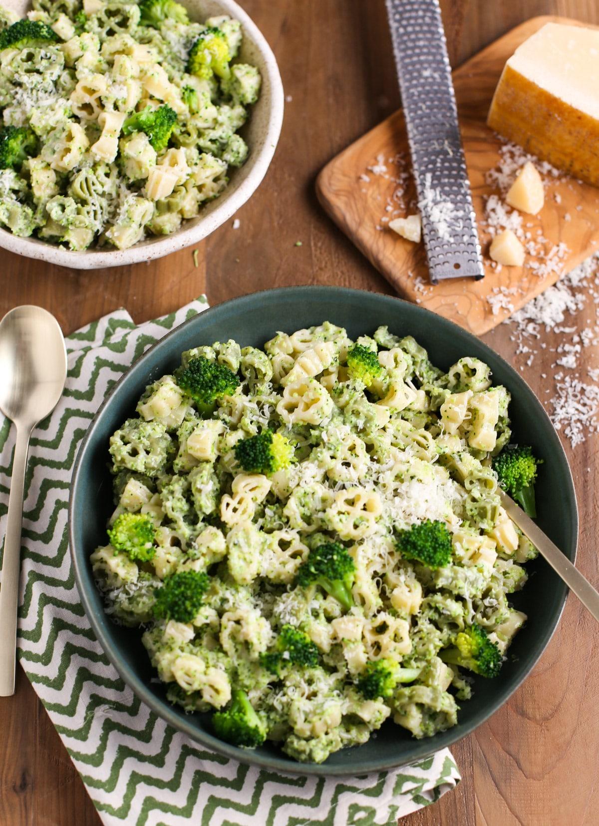 Close up of pasta bowl with cheese grater and fresh Parmesan around