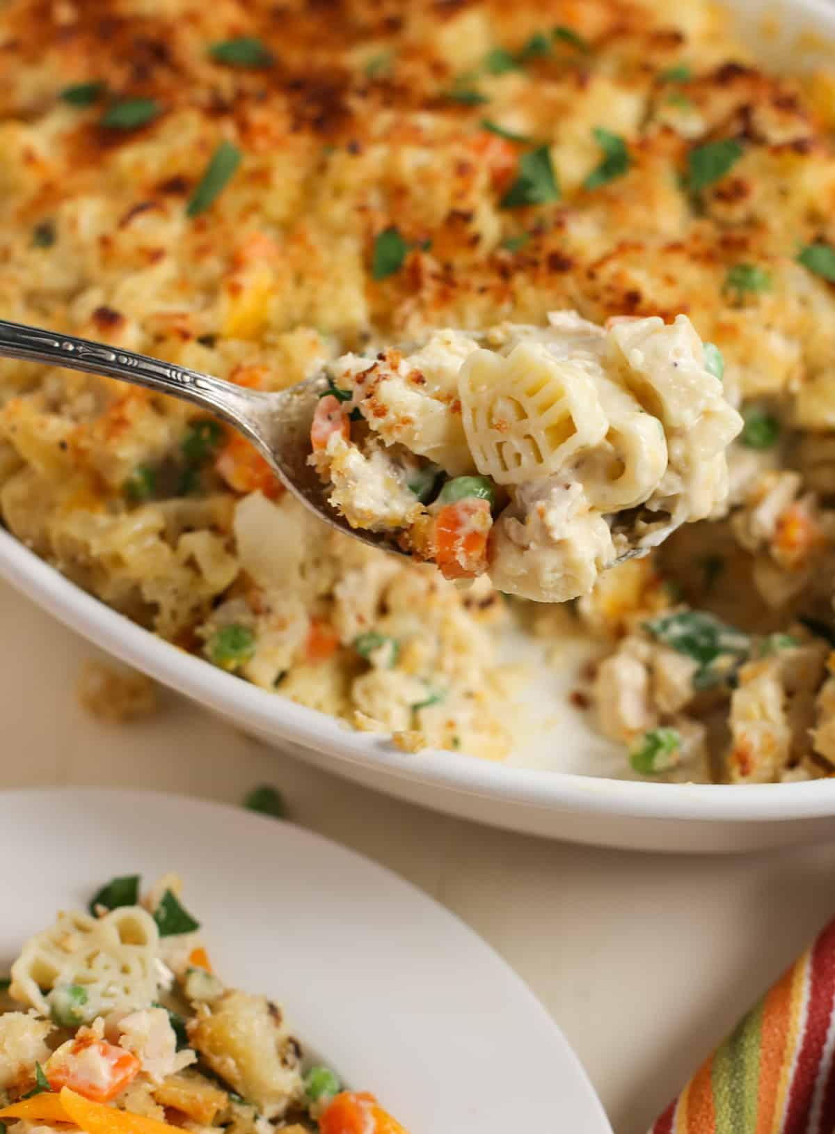 Large casserole with close up of a bite on a spoon featuring the barn shaped pasta.