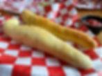 close up photo of breadsticks on red and white paper