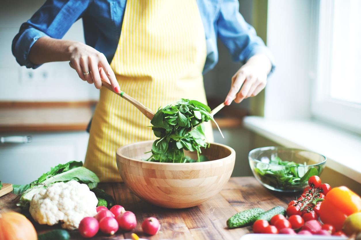 VegNews.WomanCookingSpinach.Getty