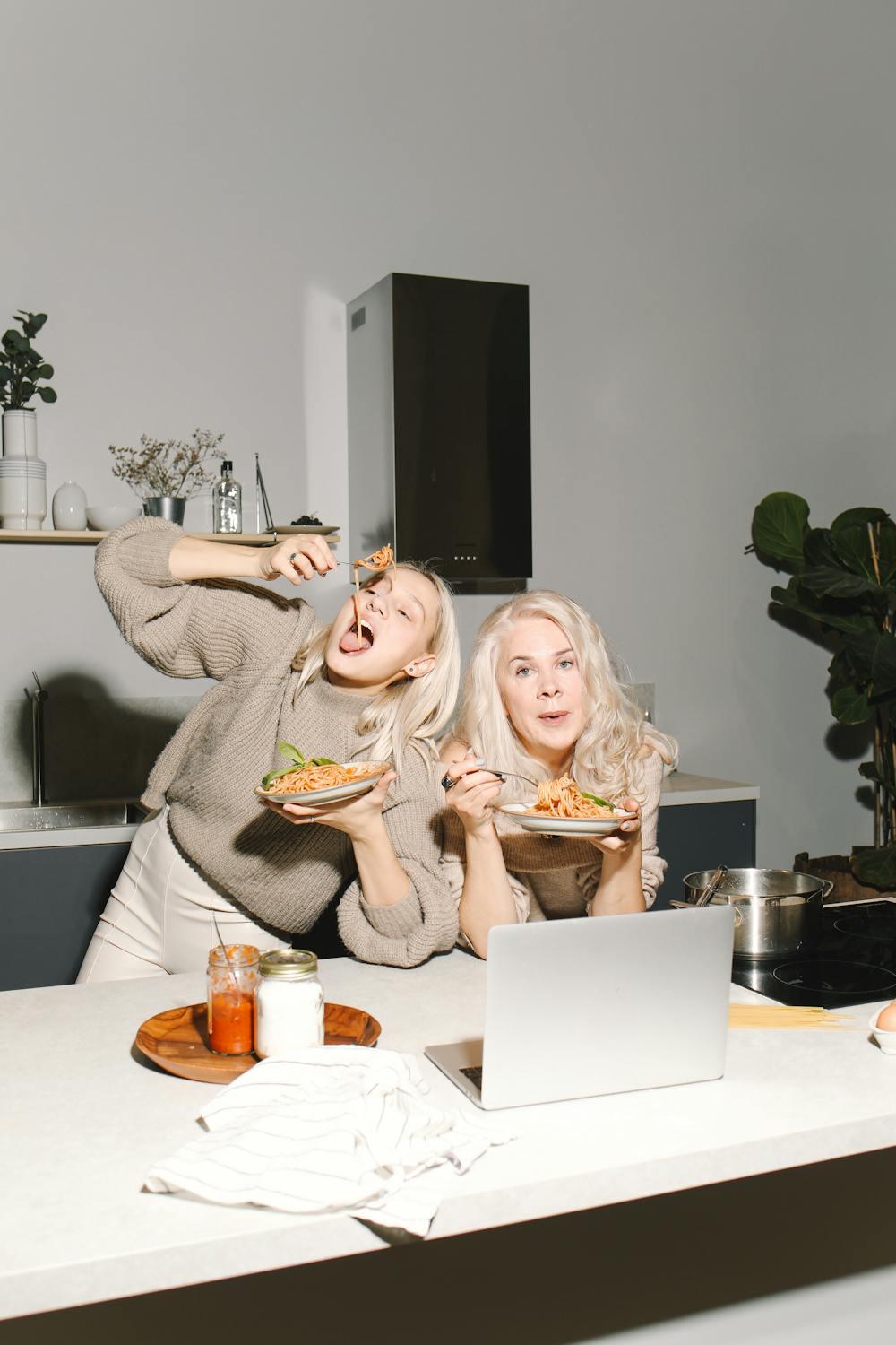 two women eating pasta