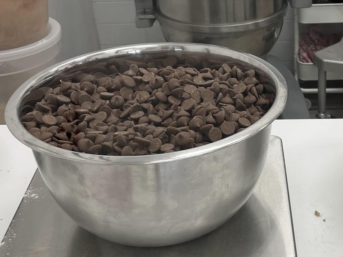 Crumbl cookies ingredients with chocolate chips in a bowl on top of a counter.