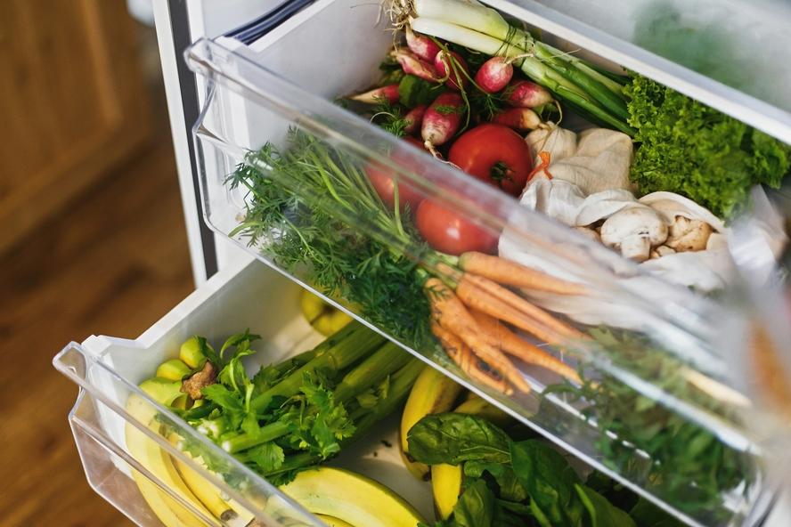 Image of an open refrigerator with two clear open drawers showcasing lots of fresh fruit and vegetables.