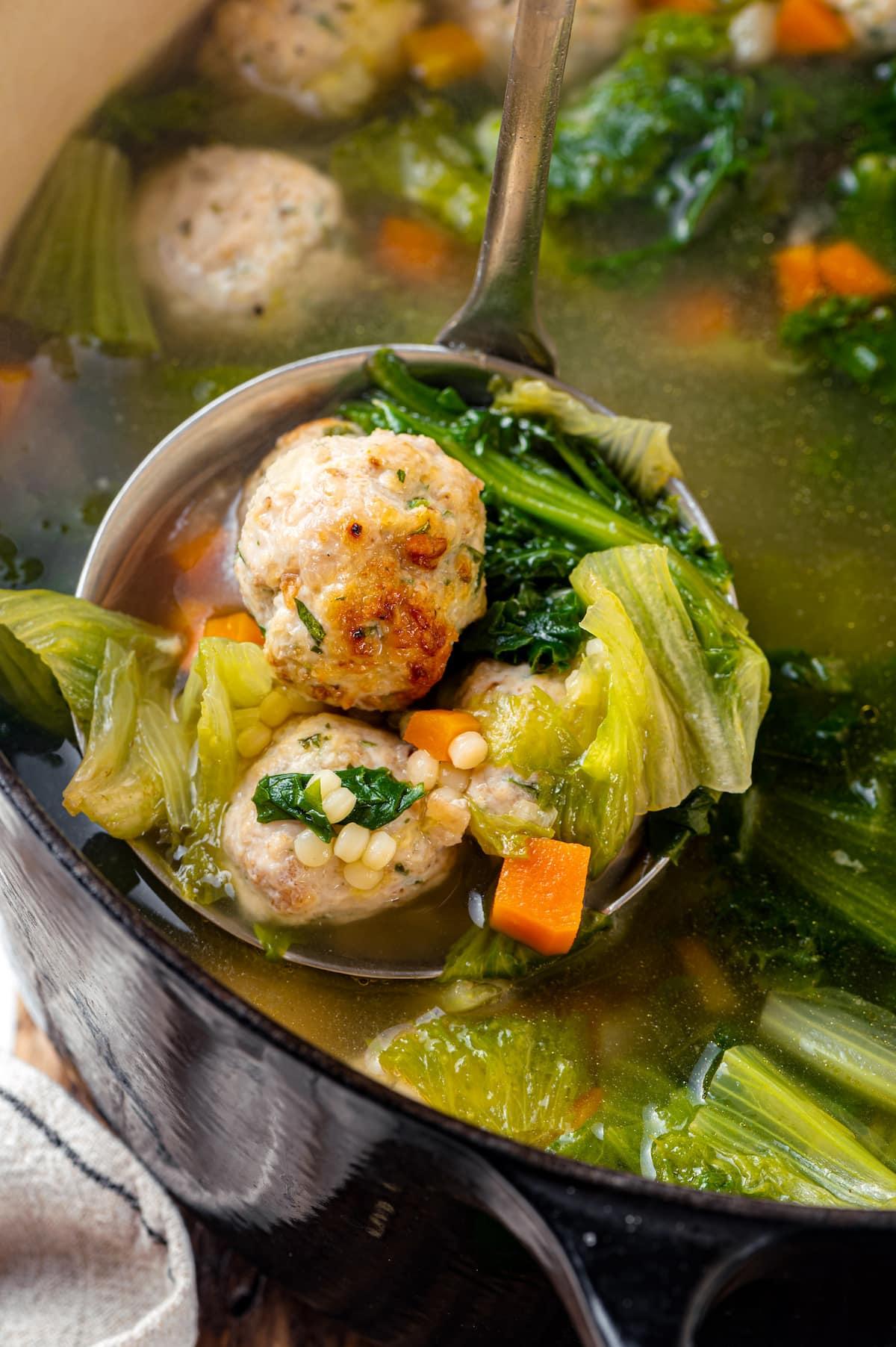 A ladle of Italian wedding soup over a pot