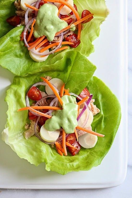 This low-calorie, low-carb tuna lettuce wrap with avocado yogurt dressing transforms ordinary canned tuna into a tasty light lunch filled with hearts of palm, tomatoes, carrots and onion.