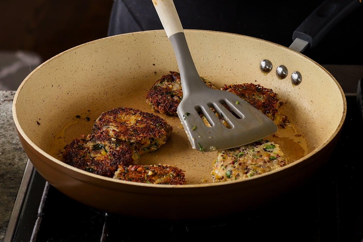 flipping the browned tikkis to cook the other side