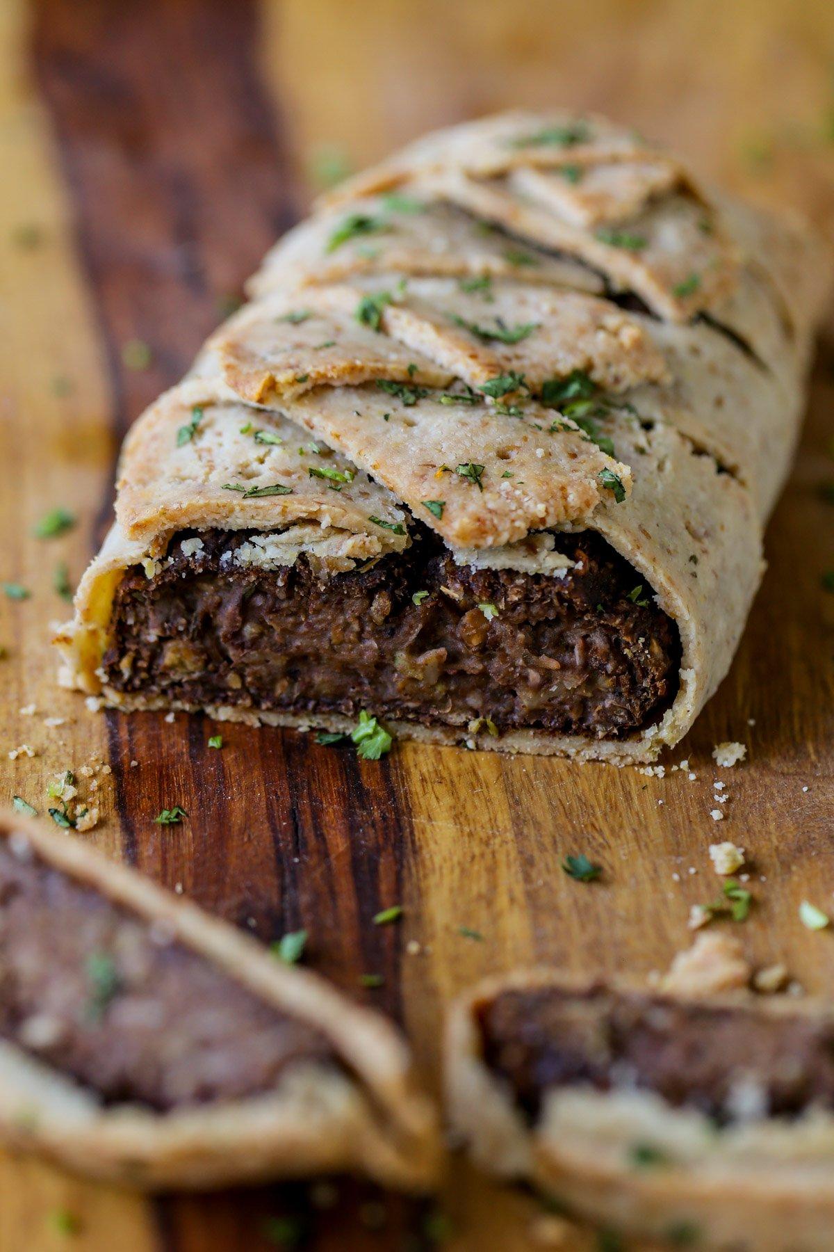 gluten-free vegan beef Wellington on a cutting board after baking and slicing