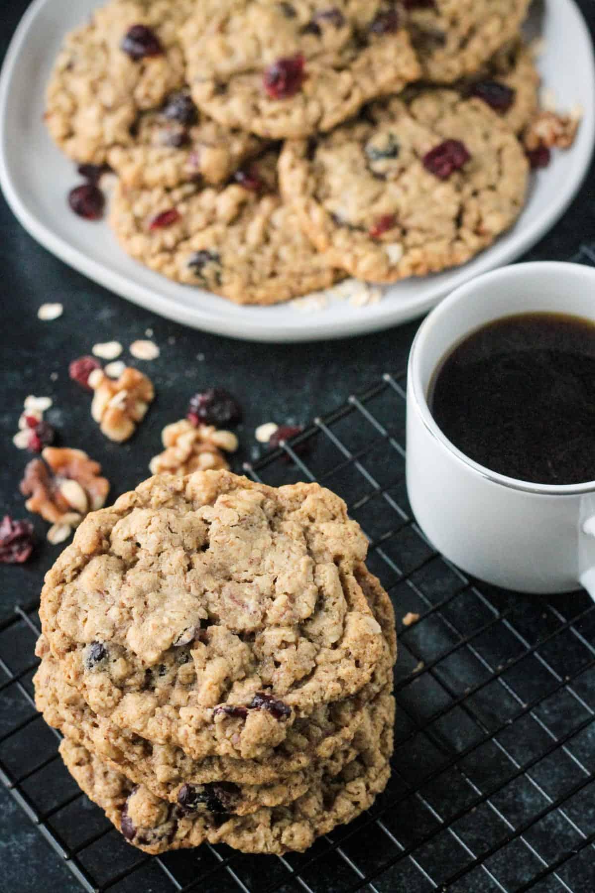 Overhead view of a stack of cookies on a cooling rack next to a cup of coffee.